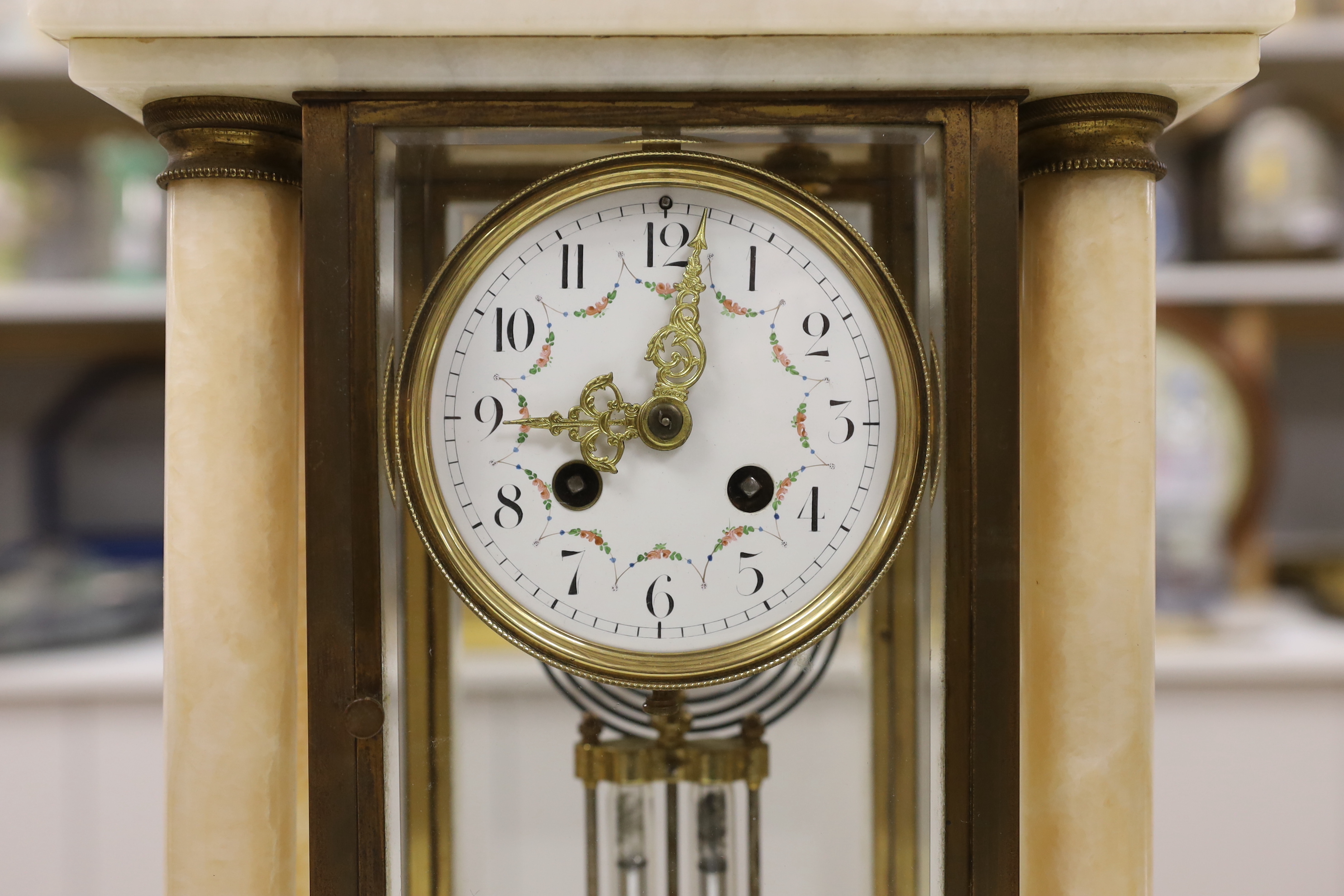 An early 20th century French four glass portico clock garniture with mercury pendulum, 50cm